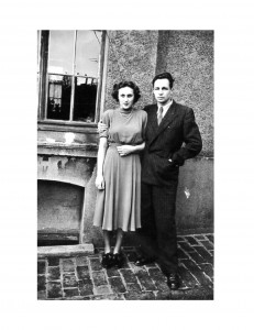 a young couple posing in front of a house