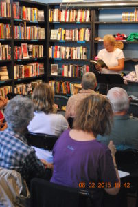 woman in bookstore reading in front of audience