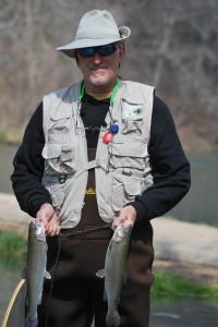 Man with two trout standing in stream
