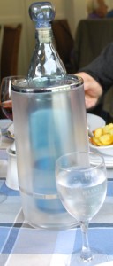 Bottle of mineral water with glass on table