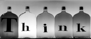 Five glass bottles with the letters of think written across 
