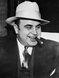 black and white photo of Al Capone in white hat and with cigar