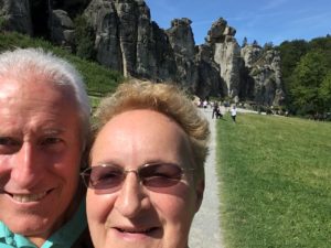 woman and man in front of large rock formation