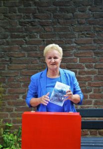 Frau an Podium mit Buch