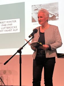 Frau an micro hält Vortrag