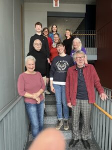 Maenner und Frauen auf Treppe posierend