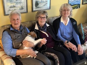 three woman and dog on sofa