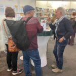 Frau am LBM Stand mit Gästen