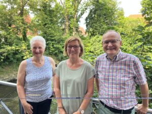 2 Frauen und ein Mann vor Bäumen
